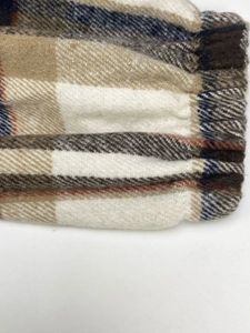 Detailed macro shot of the elastic cuffs on a long-sleeved plaid hooded jacket