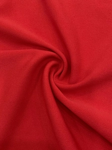 Vue macro détaillée de la texture du tissu rouge vif avec des plis drapés doux