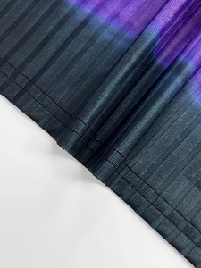 Detail of pleated fabric hem with black to purple gradient and neat stitching finish