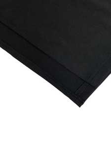 Gros plan sur les coutures et la texture du tissu d'un ensemble jupe noire à manches longues