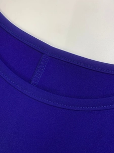 Close-up of crew neck stitching and mesh texture on dark blue commuter dress