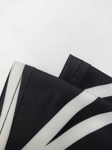 Détail du tissu de robe noire à rayures blanches et couture à double aiguille