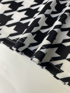 Détail de couture professionnelle à double aiguille sur tissu tricoté pied-de-poule