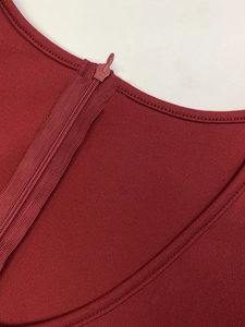 Detail of the elegant burgundy knit dress featuring a round neckline and invisible zipper