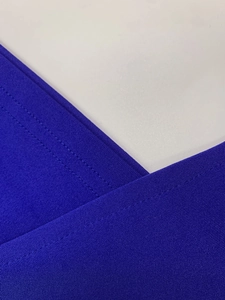 Detail of navy blue knit fabric showing clean stitching and cross-neckline texture