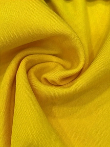 Detailed macro view of bright yellow knitted fabric texture with elegant mesh weave pattern