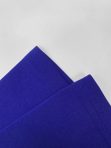 Macro shot of royal blue knit fabric showing precise double-needle stitching on the hem