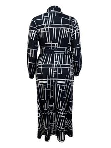 Back view of a long sleeve dress with white geometric print and waist belt detail