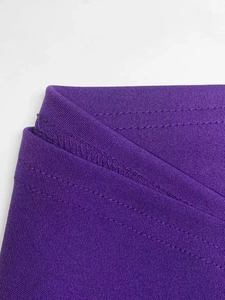 Détail de couture à double aiguille et bord surjeté sur une robe en maille violette
