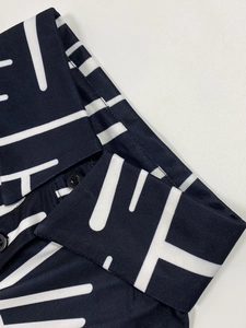 Close-up of geometric print fabric on plus size dress with buttons and fine stitching