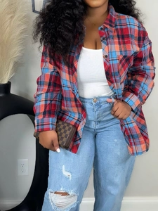Detail of red and blue plaid flannel shirt paired with a white tank top and ripped denim jeans