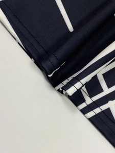 Macro shot of mesh knit fabric showing geometric print and double-needle stitching detail