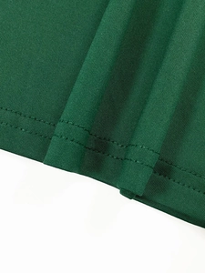 Detail shot of green ribbed knit fabric showing neat double-needle stitching on the hem