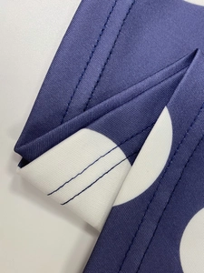 Dettaglio del tessuto blu navy a pois con finitura di alta qualità a doppia cucitura