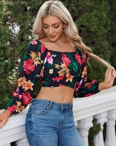 Dettaglio del crop top floreale con design a incrocio in vita e polsini elastici