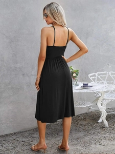 Detail of elegant black backless dress with fine straps and pleated waist tailoring