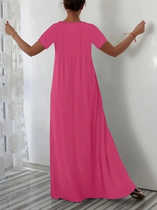 Back view of a rose pink maxi dress with short sleeves and a flowing long skirt silhouette