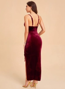 Close-up of elegant burgundy velvet dress showing side slit and fine fabric texture