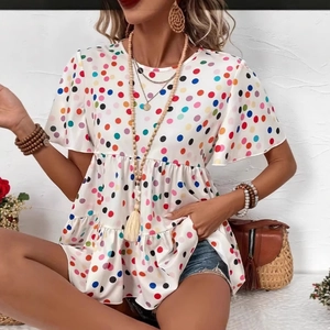 Detail view of the colorful polka dot print and layered ruffled hem on white summer t-shirt