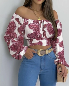 Dettaglio di un crop top a spalle scoperte con stampa paisley rosa e maniche a sbuffo