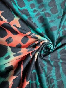 Maxi dress with vibrant tie-dye leopard print in teal and orange with a slit hemline