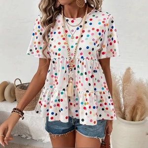 Close-up of white summer blouse with colorful polka dots and babydoll pleated waist