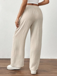 Back view of beige high waist wide leg pants with textured fabric and elastic waist