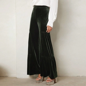 Detail of dark green velvet wide-leg trousers with high waist and layered tier design