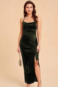 Detail of elegant dark green velvet dress featuring a high slit and pleated ruched texture