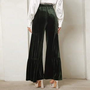 Rear view of high-waist velvet wide-leg trousers in dark green with horizontal paneling