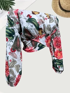 Dettaglio top floreale con spalle scoperte, design incrociato e maniche a sbuffo