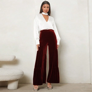 Detail of high-waisted velvet wide-leg trousers in wine red with layered hem design