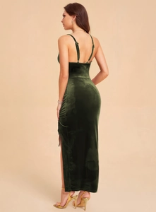 Detail of elegant dark green velvet dress featuring a high side slit and soft texture