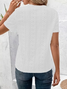 Detail of the white lace T-shirt featuring intricate hollow floral embroidery on the back