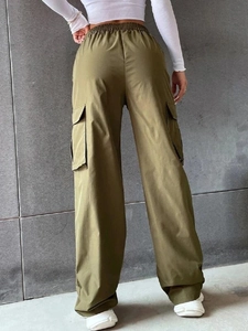 Dettaglio dei pantaloni cargo verde oliva con vita elastica e tasche con patta sul retro