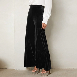 Detail of black velvet high-waisted wide-leg pants with layered tiered ruffle design