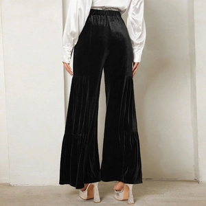 Back view of black velvet high-waisted wide-leg trousers with elegant ruffled hem details