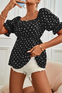 Detail of square neck and puff sleeves on a black and white polka dot top for women