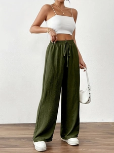 Detail of high waisted wide leg trousers in olive green with drawstring and elastic band