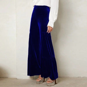 Detail of royal blue velvet wide-leg trousers featuring layered pleated tiered design