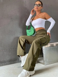 Dettaglio dei pantaloni cargo verde militare con ampie tasche a patta e taglio a gamba larga