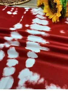 Detail shot of red and white tie-dye fabric with sunflower and straw basket decoration