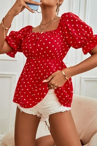 Detail of red polka dot top with puff sleeves and retro square neckline on model