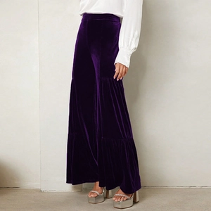 Detail view of high-waisted deep purple velvet wide-leg trousers with tiered pleats design