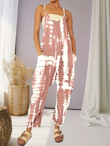 Detail of tie-dye wide-leg jumpsuit featuring functional large side pockets and spaghetti straps