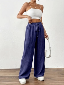 Close-up of high-waisted dark blue wide leg trousers with adjustable drawstring waistband