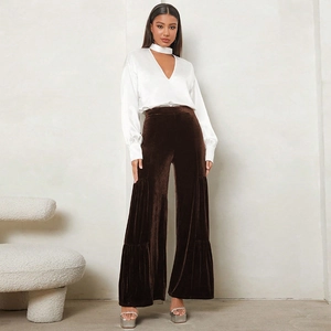Detail of high-waisted velvet wide-leg trousers paired with white satin choker blouse
