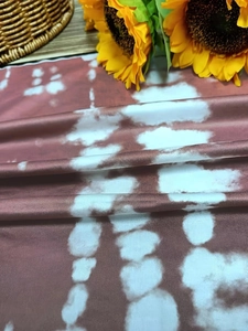 Detailed view of the dark red tie-dye fabric texture with a soft glossy finish