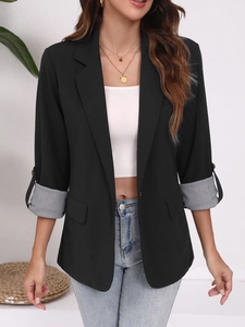 Détail du blazer noir avec revers rayés aux poignets et design à boutonnage simple