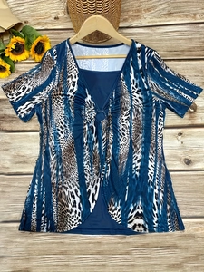 Close-up of V-neck tunic with animal print patchwork and metal ring detail